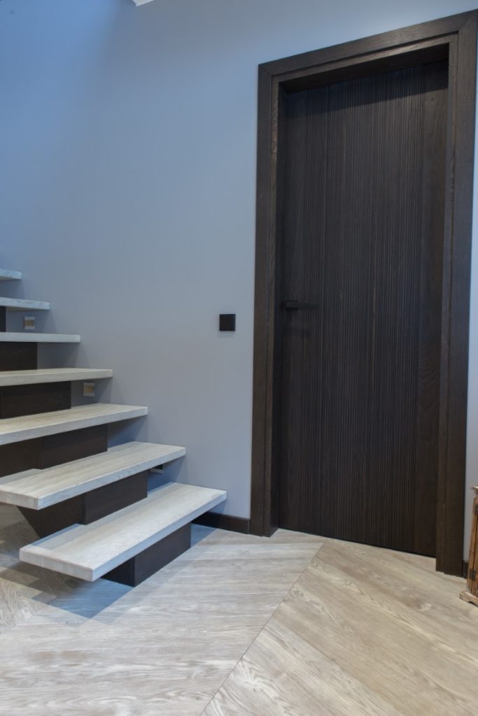 Medinės grindys: T-1010 Amiata. Medinės masyvo durys: 3479 Antique, modelis Velvet.