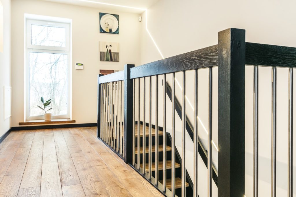 Mediniai ąžuolo masyvo laiptai,  durys ir grindys: spalvos 3481 Riešutas ir RAL 9005.