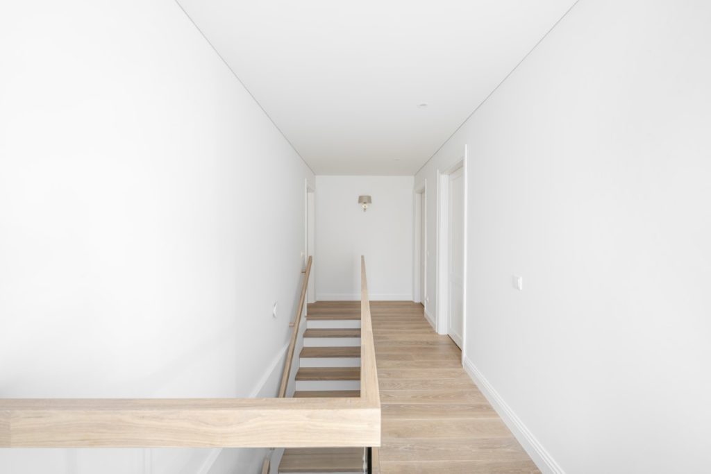 Medinės grindys, ąžuolo masyvo laiptai: spalva 3408 Balta. Medinės durys: dažytos RAL 9003, modelis ED2F.