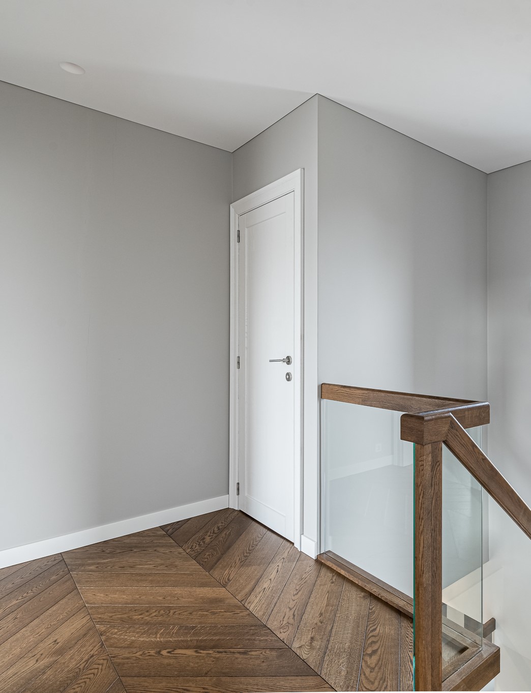Neįpareigojanti klasika: subtilus Chevron parketo, ąžuolinių laiptų ir vidaus durų derinys