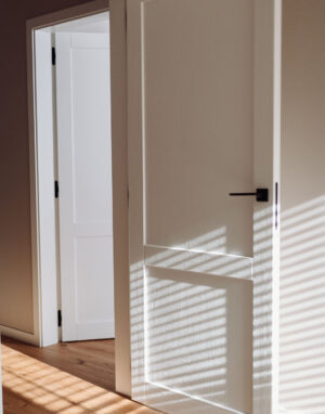 Subalansuotas interjeras: grindys, durys, net turėklai laiptais sumaniai suderinti tarpusavyje