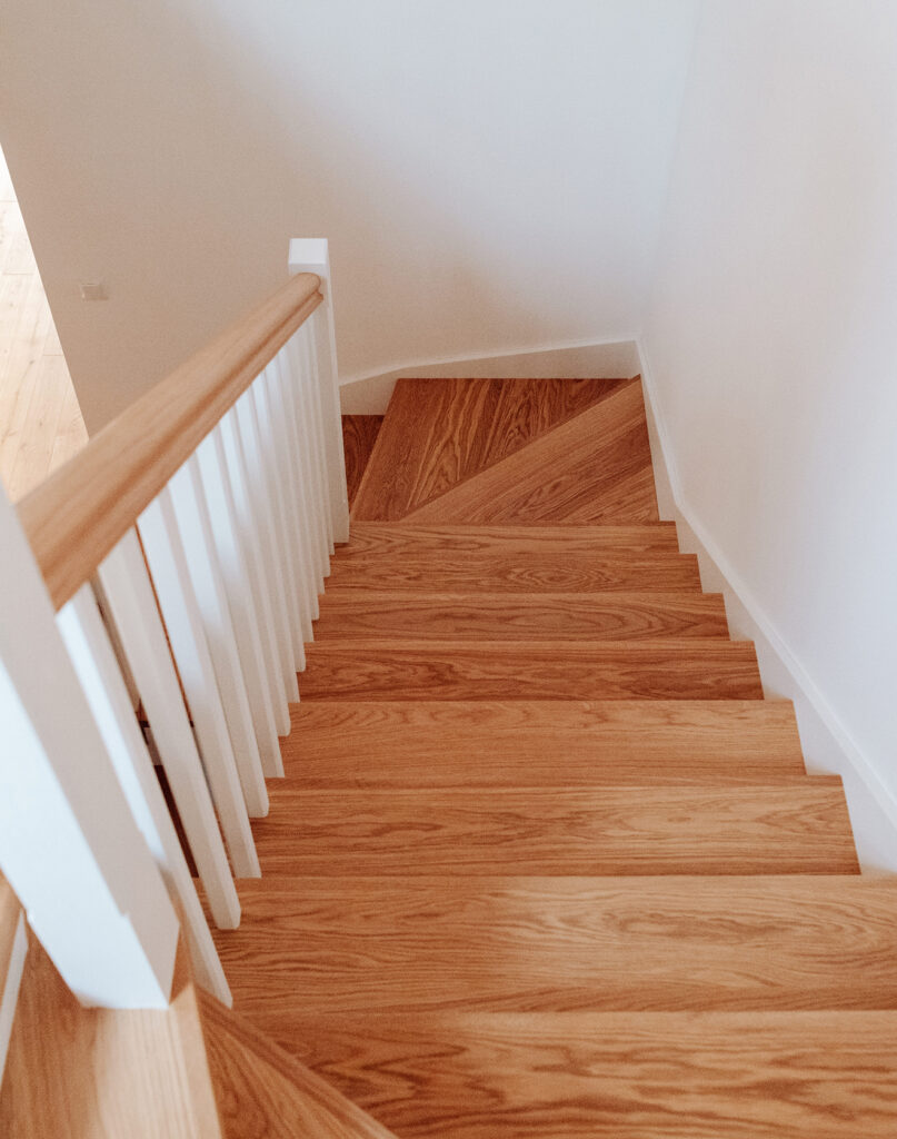 Subalansuotas interjeras: grindys, durys, net turėklai laiptais sumaniai suderinti tarpusavyje