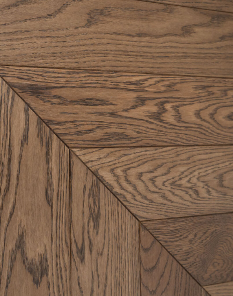 Skirtingas namų erdves suvienijo sodraus atspalvio Chevron parketas