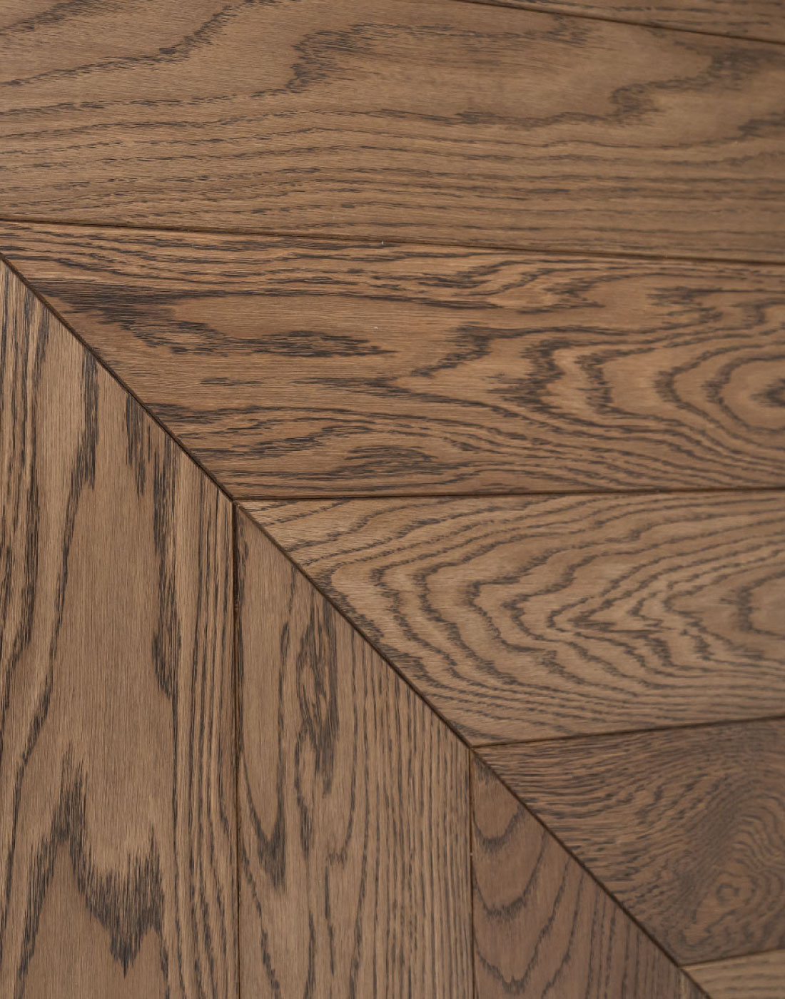 Skirtingas namų erdves suvienijo sodraus atspalvio Chevron parketas